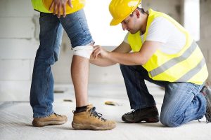 Construction Worker Bandaging His Colleagues Leg