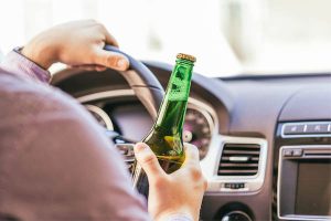 Man Holding A Beer Behind The Wheel