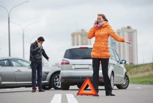 Woman Talking On A Phone Next To A Car Crash Scene