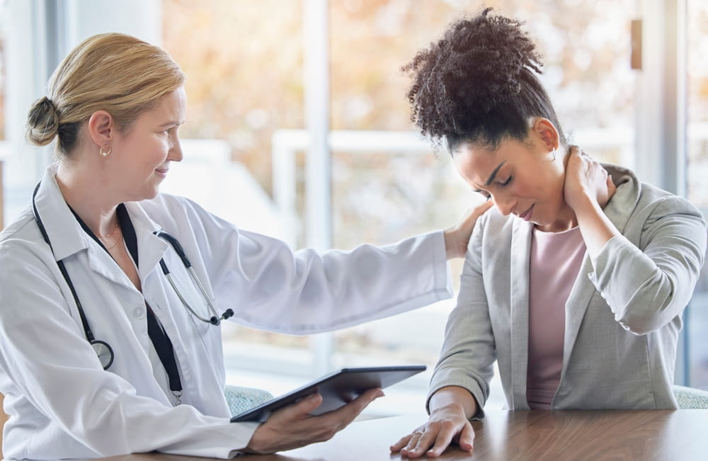 Doctor Examining A Patient Who Is Holding Her Neck