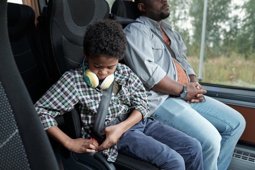 Boy Fastening His Seatbelt Sitting In A Bus