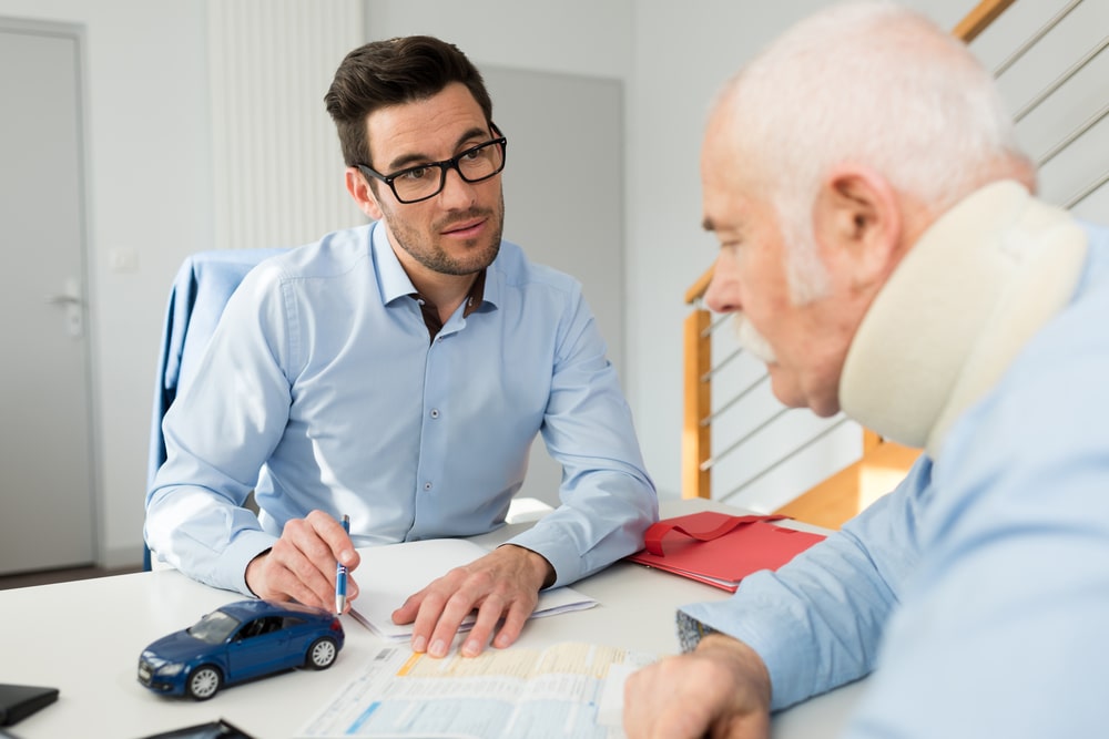 Man With A Cast On His Neck Talking With A LAwyer