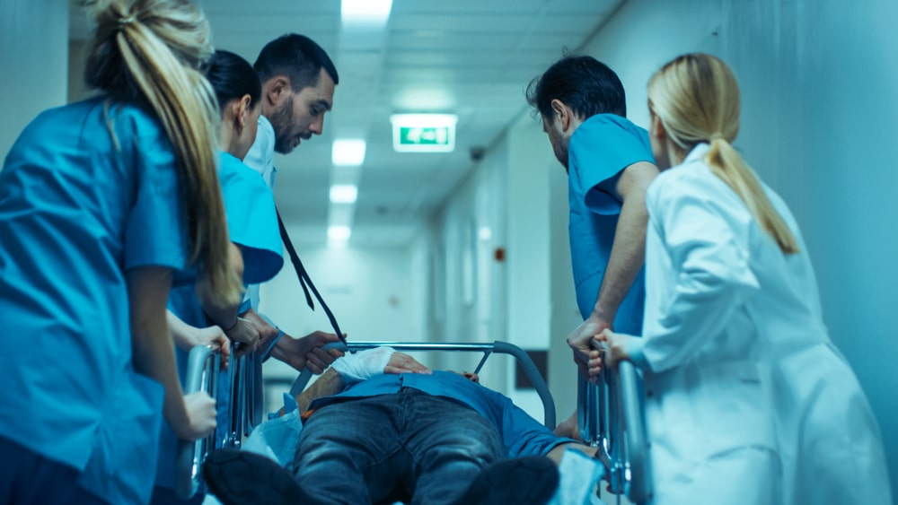 Doctors Pushing A Patient Laying On A Medical Bed