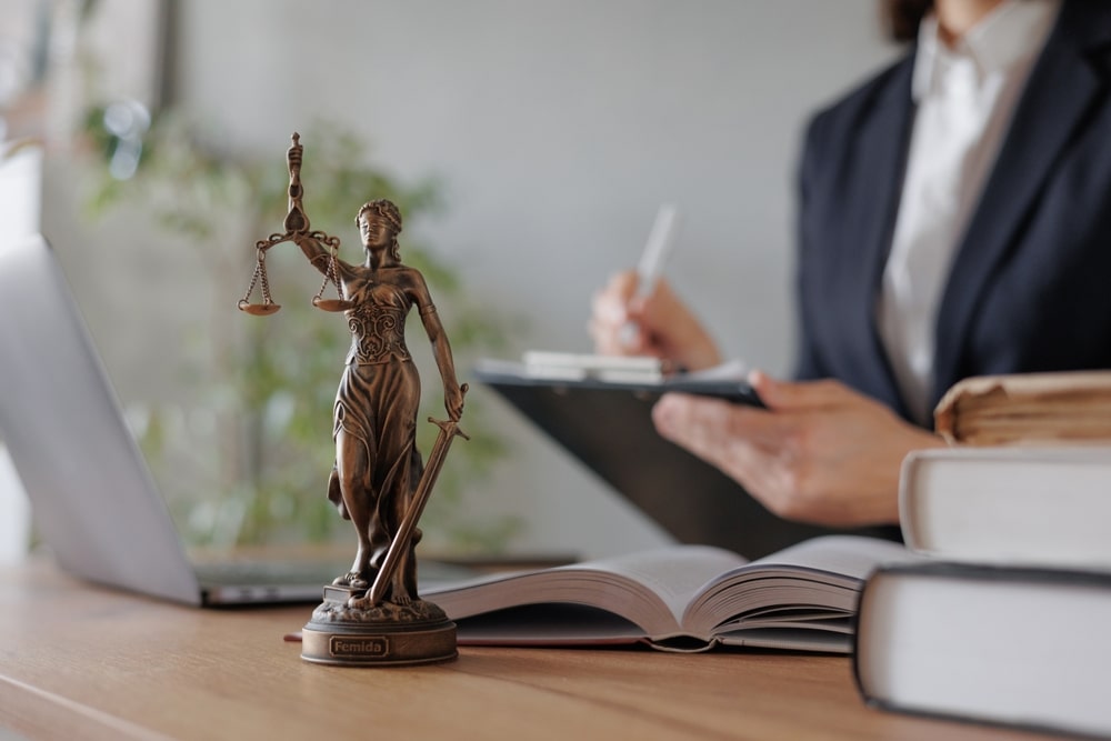 Statue Of Lady Of Justice And A Lawyer In The Background