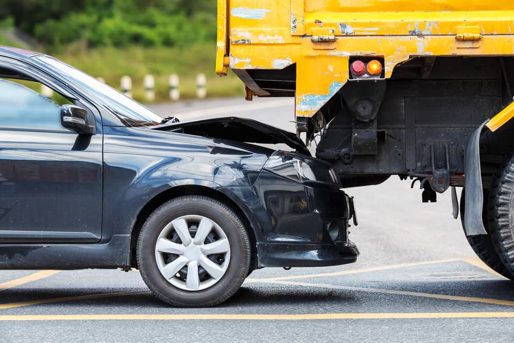 Black Car Frontally Crashed Into A Yellow Truck